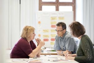Eine Gruppe von 3 Teilnehmern arbeitet zusammen