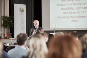 Ein Referent spricht in der Aula der ALP vor Publikum
